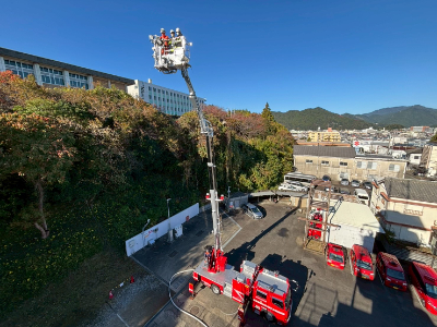 はしご車に乗車し、はしごを高々と伸ばしている写真です。