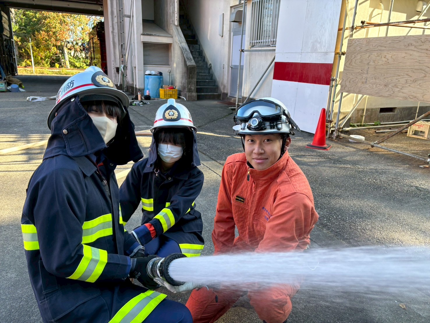 クラブ員と消防士が一緒に放水をしている写真です。