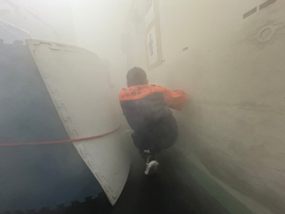 火事の煙を体験、煙を避けるため、屈んで壁伝いに避難している写真です。