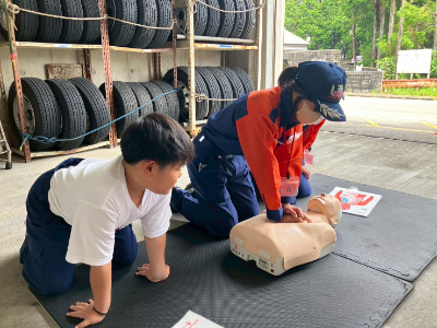 訓練人形を使い、心肺蘇生法を練習している写真です。