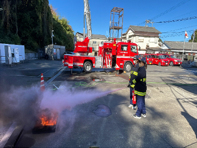 消火器を使用し、消火訓練をしている写真です。